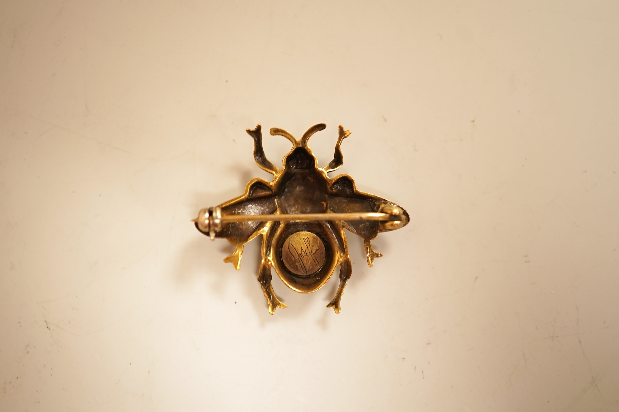 A mid 20th century North American gilt metal bee brooch by Joseff, wing span 30mm, together with a hard back copy of 'Jewelry of the Stars, Creations from Joseff of Hollywood' by Joanne Dubbs Ball.
